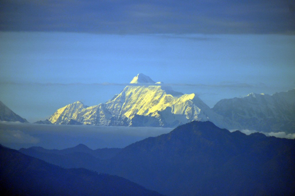 As the golden glow of setting sun lights up the Himalayan Trishul ...